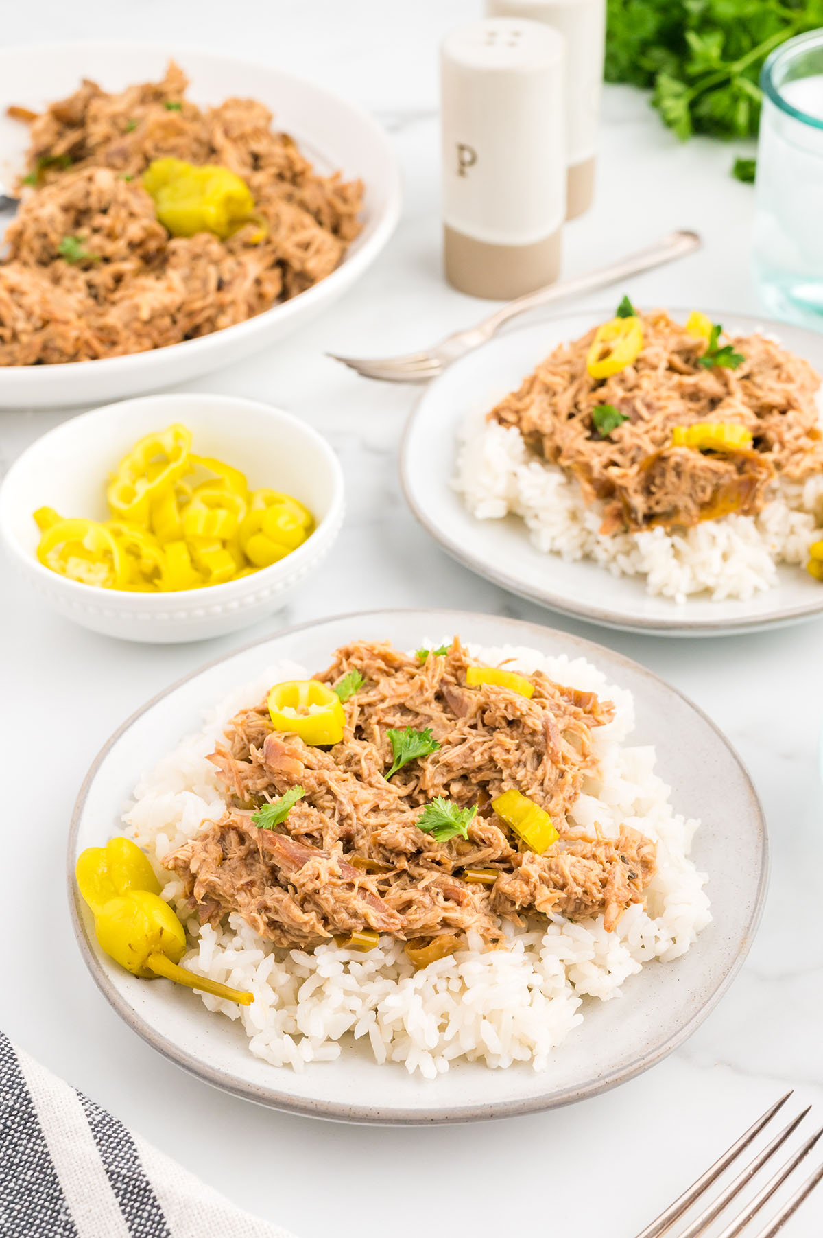 Mississippi Chicken served over rice on a white plate.