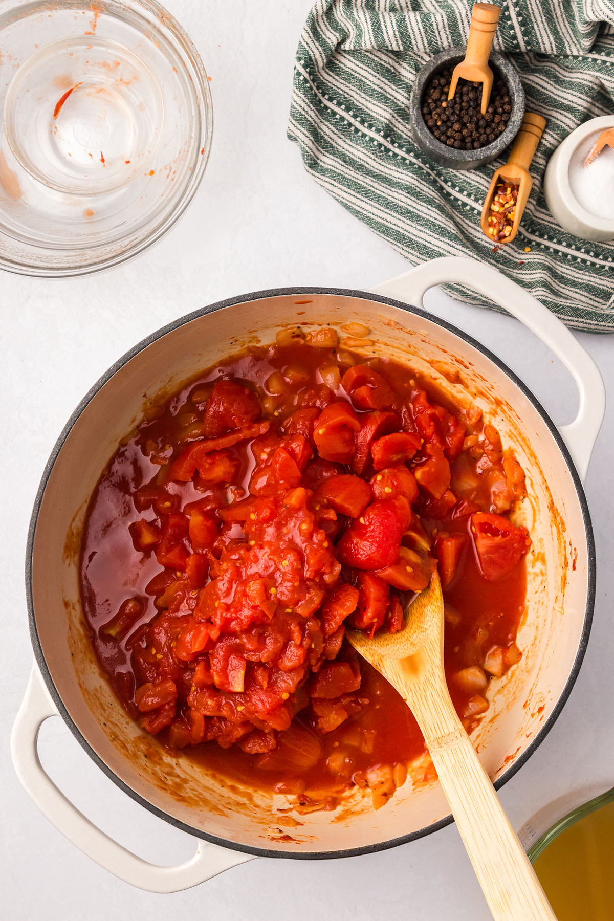 Chopped tomatoes are added to the onions and garlic in the large pot.