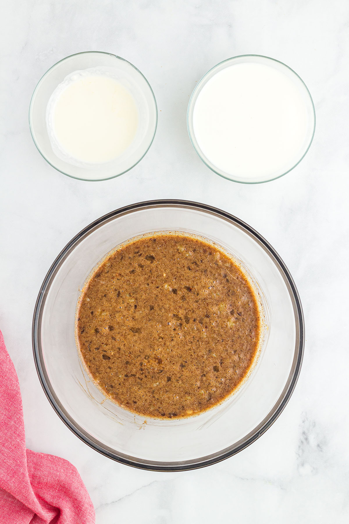 Eggs, melted butter, molasses, pancake syrup, brown sugar, and spices in a glass mixing bowl.