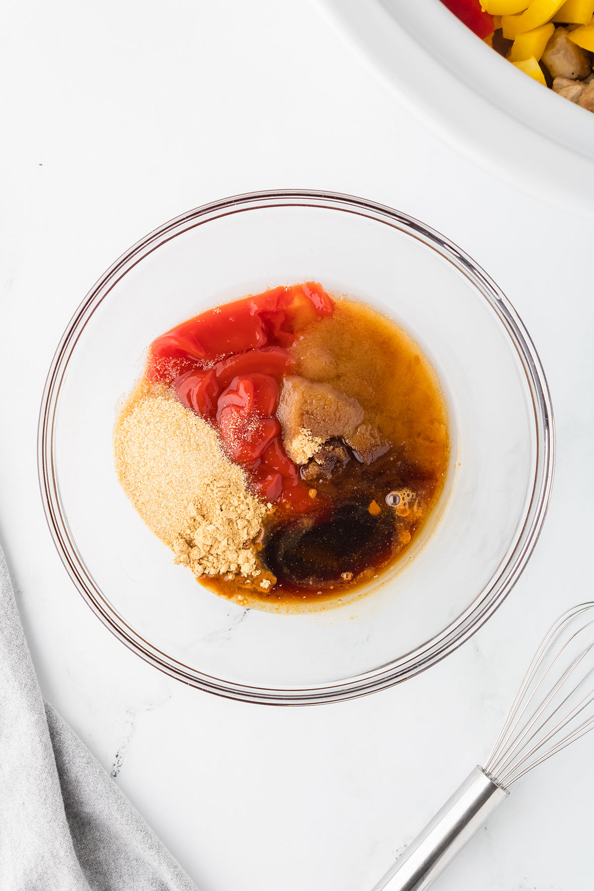 Ketchup, brown sugar, rice vinegar, soy sauce, onion powder, and ginger in a glass mixing bowl.