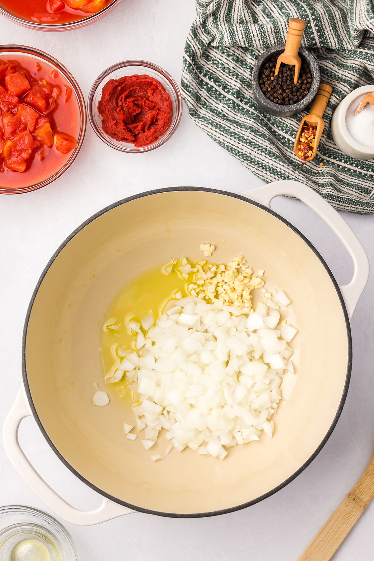 Olive oil, onion, and garlic are added to a large pot.