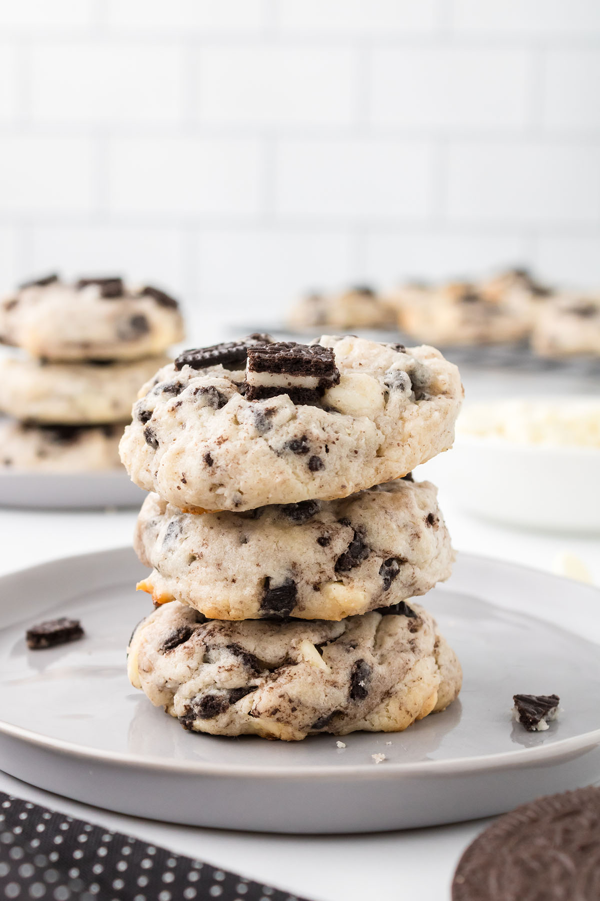 Three Cookies and Cream Cheesecake Cookies stacked on a white plate.