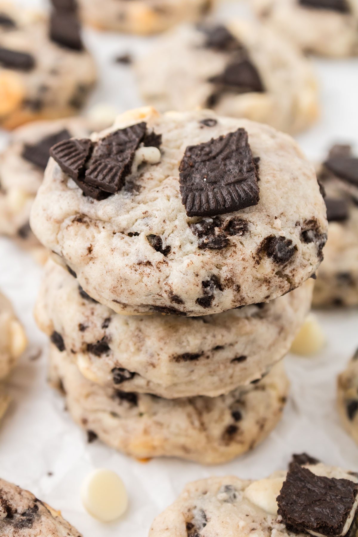Cookies stacked together on parchment paper.