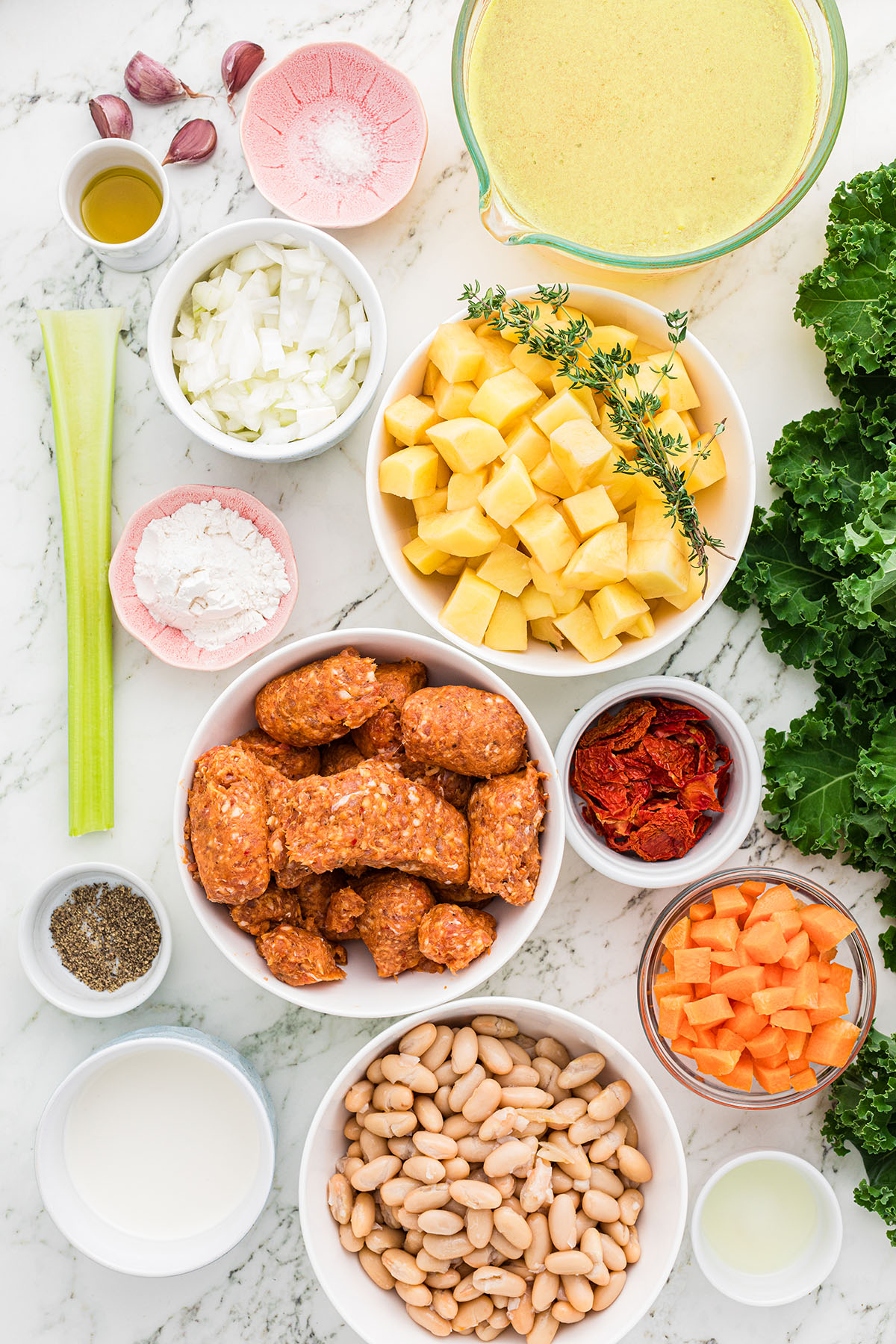 Ingredients to make Sausage and Kale Soup are set out on the counter.