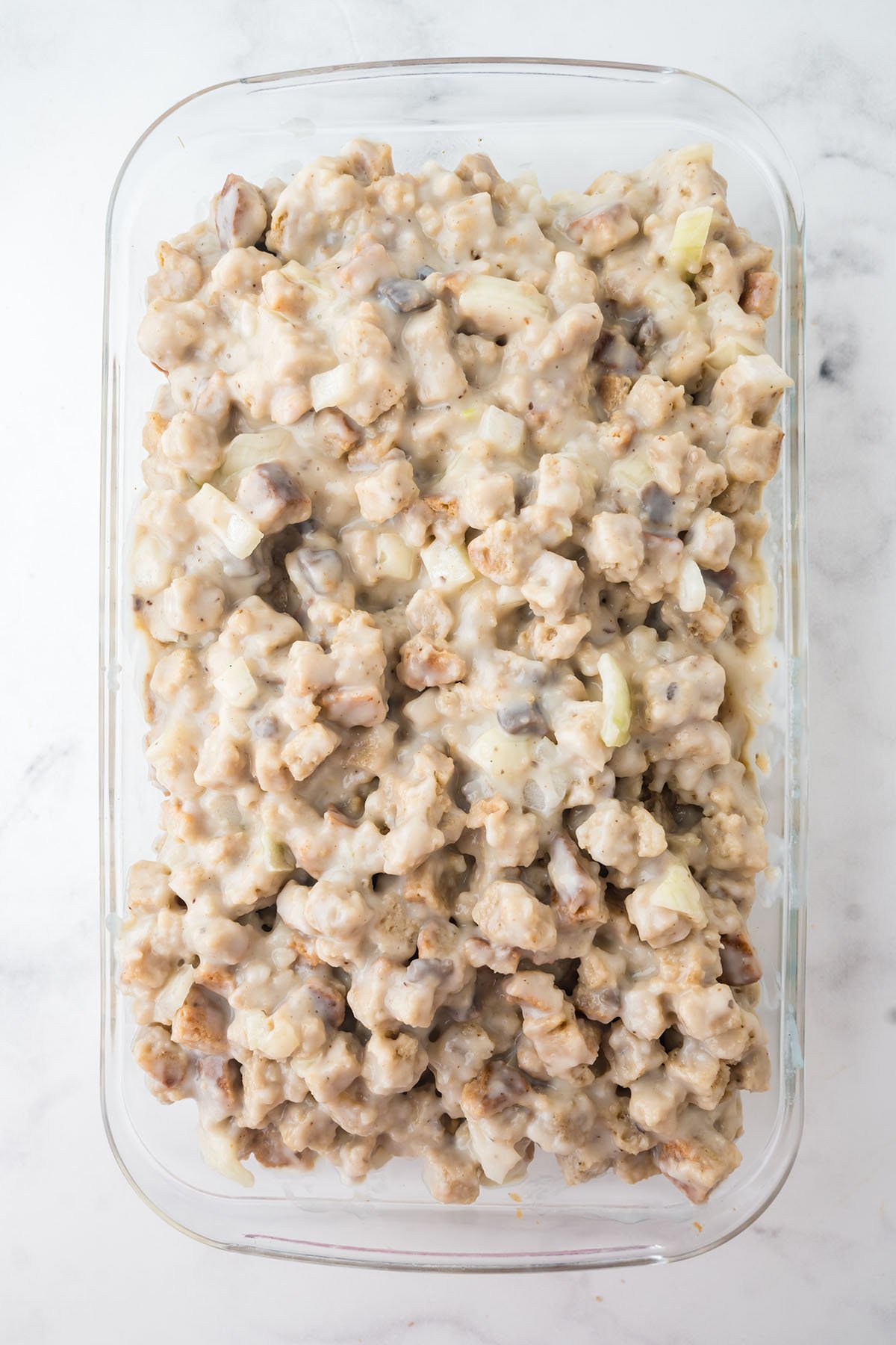 Pork chops topped with stuffing in the baking dish.