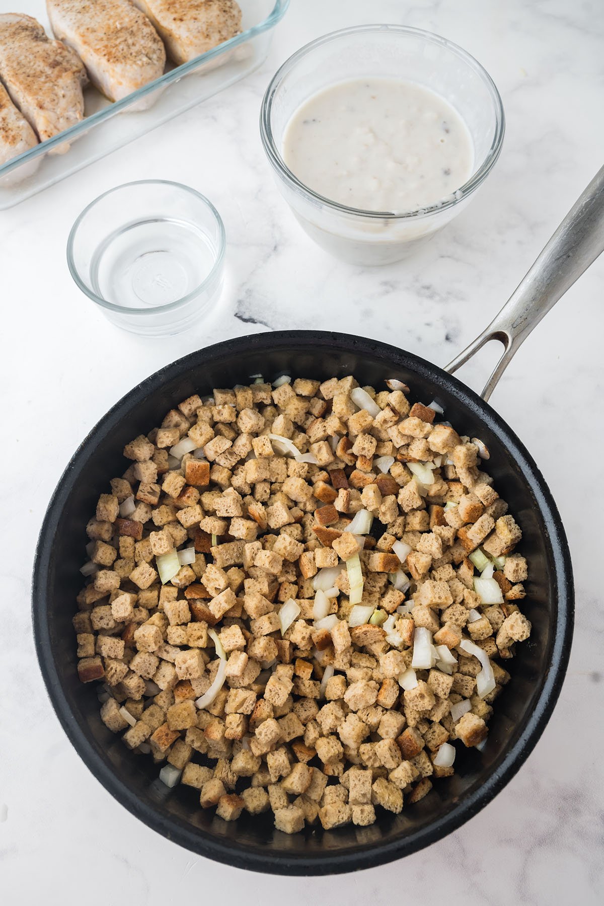 Bread cubes, melted butter and diced onion in a skillet.