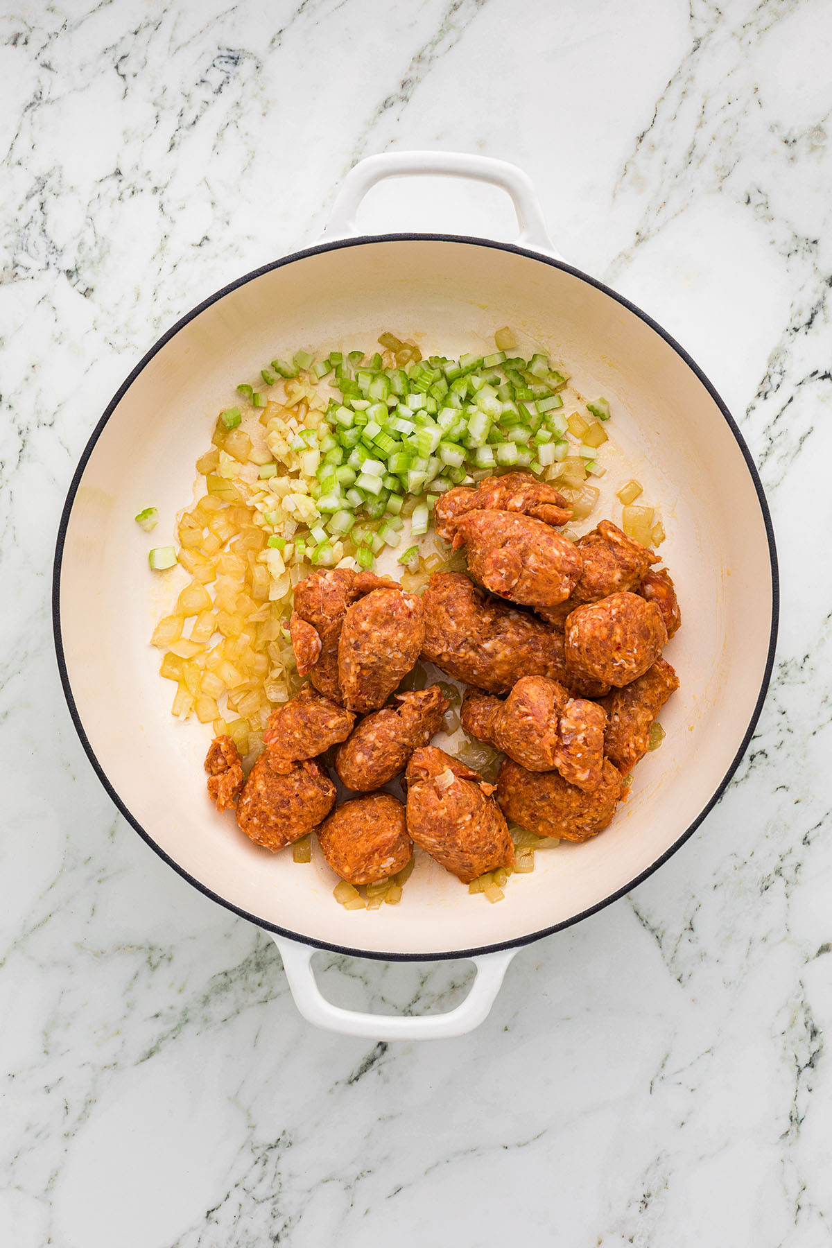 Onions, celery, garlic, and Italian sausage in a skillet.