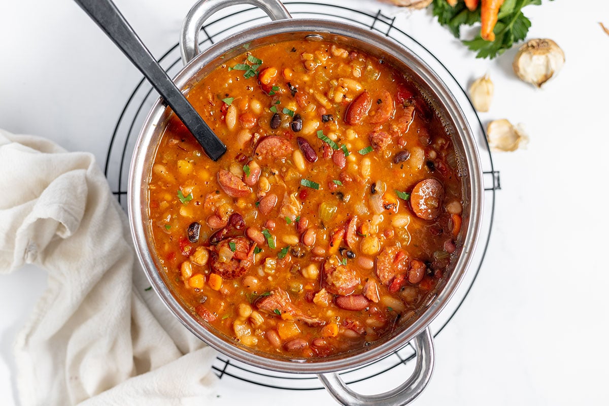 15 Bean Soup with Sausage and Ham in a large pot with a serving spoon.