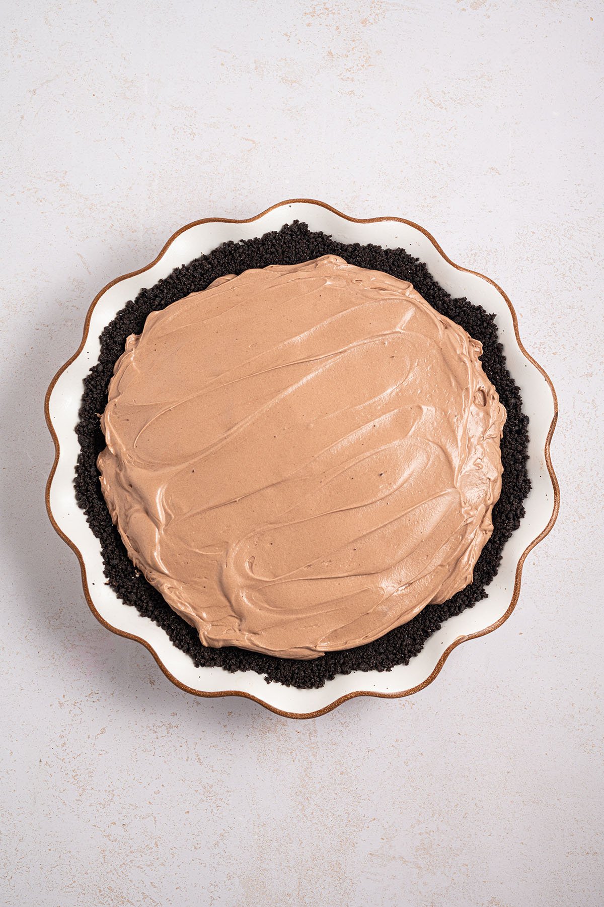 Chocolate Cheesecake Pie filling with an Oreo crust in a pie plate.