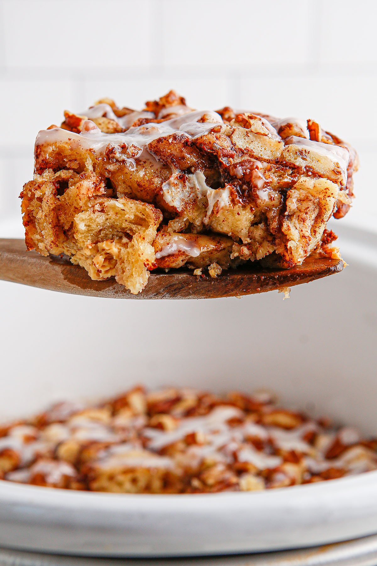 A serving of Cinnamon Roll Casserole on a wooden spoon.