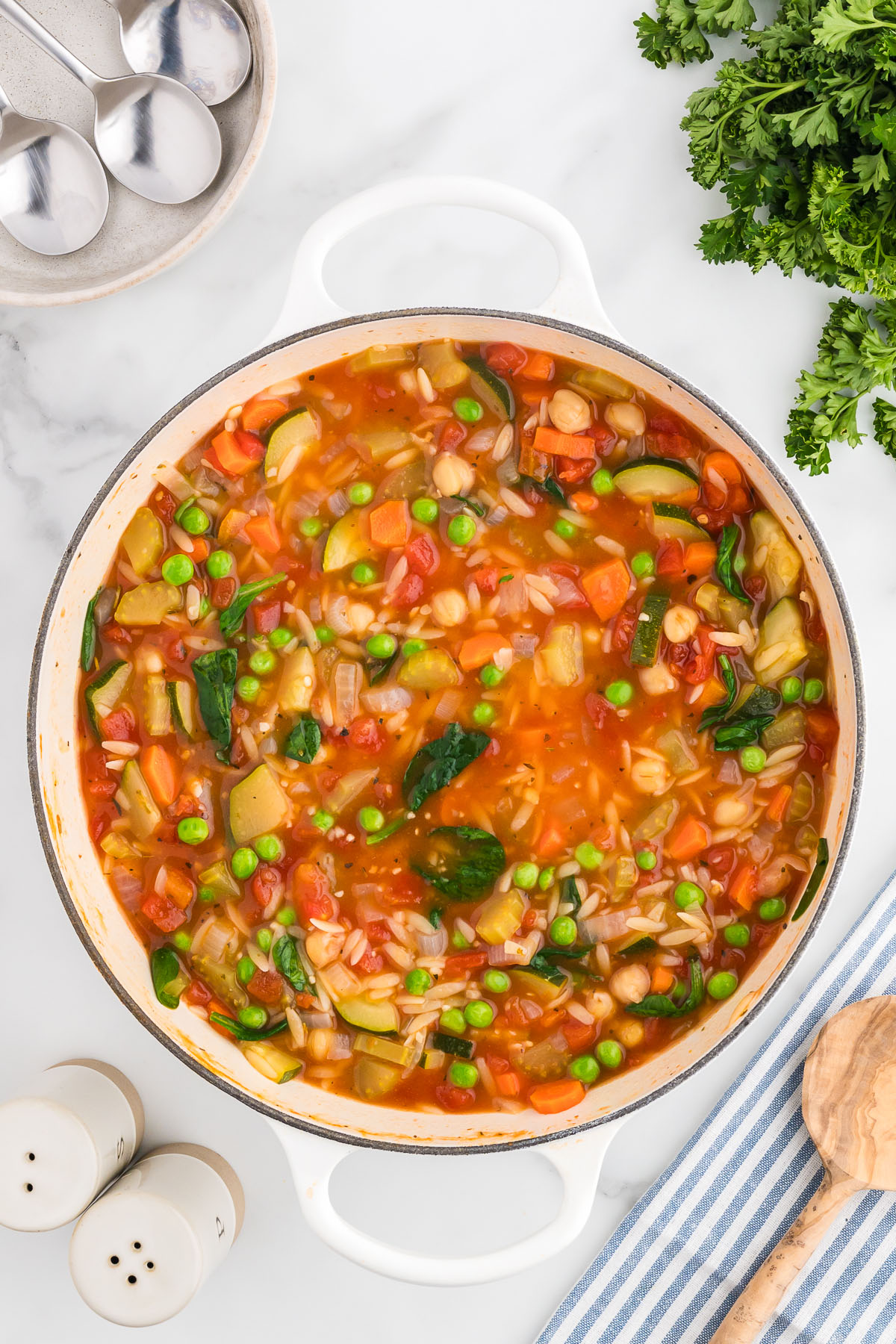Vegetable orzo soup in a large pot is ready to serve.