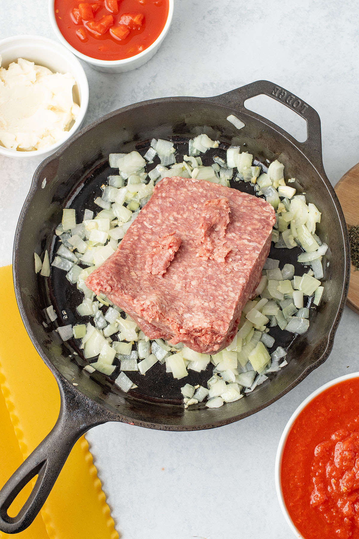 Ground beef added to the onion and garlic in  the skillet.