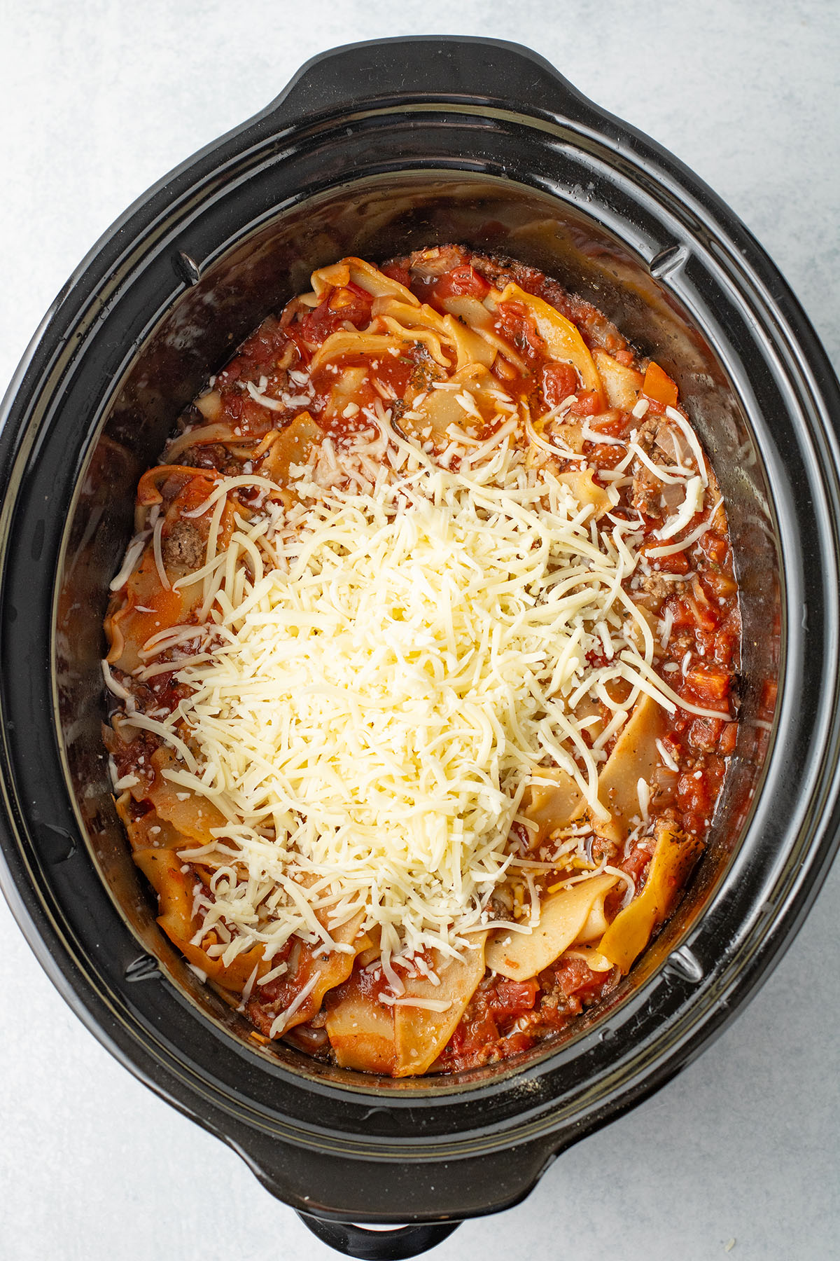 Mozzarella cheese added to the lasagna soup in the slow cooker.